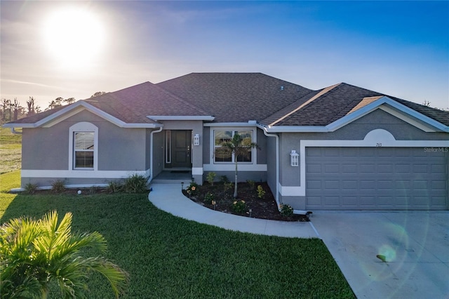 ranch-style home featuring a garage and a yard