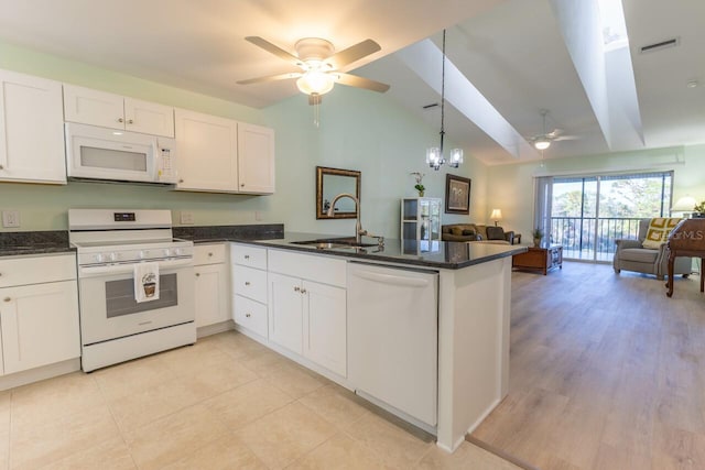 kitchen with vaulted ceiling, sink, white cabinets, kitchen peninsula, and white appliances