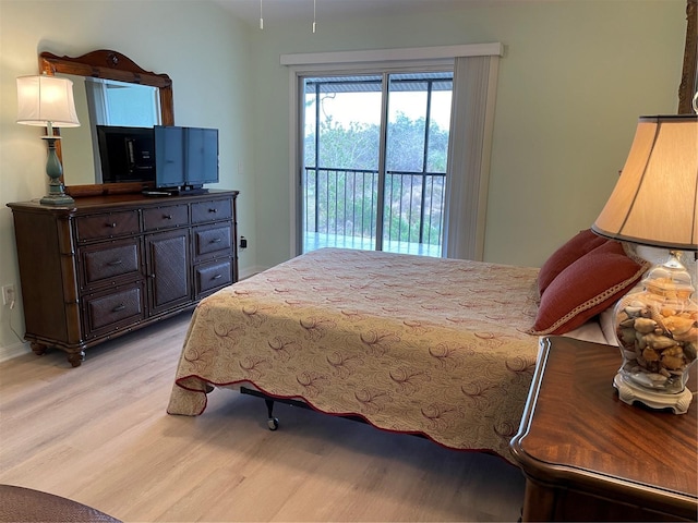 bedroom with access to exterior and light hardwood / wood-style flooring