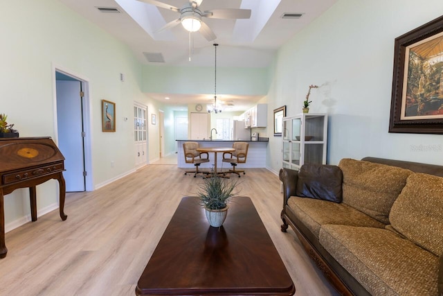 living room with lofted ceiling, sink, ceiling fan, and light wood-type flooring