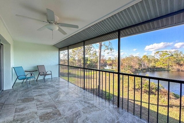 sunroom / solarium featuring a water view and ceiling fan