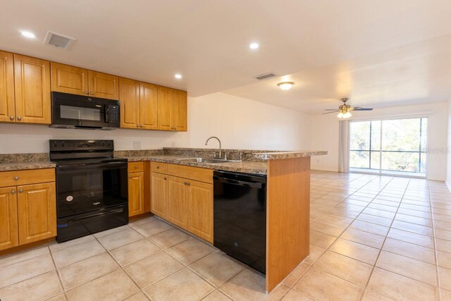 kitchen featuring kitchen peninsula, sink, light tile patterned flooring, and black appliances