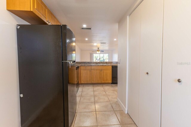 hall featuring light tile patterned floors and sink