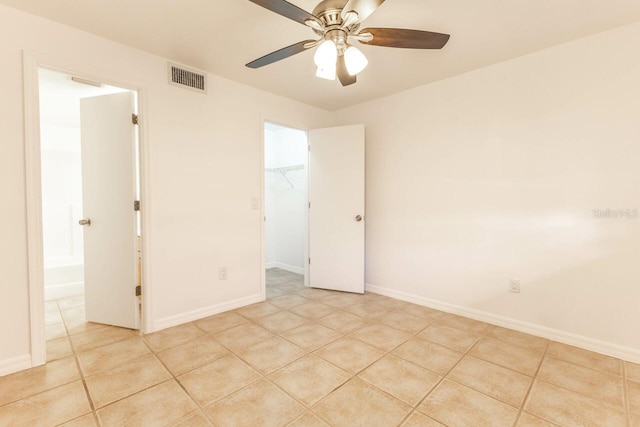 tiled spare room with ceiling fan