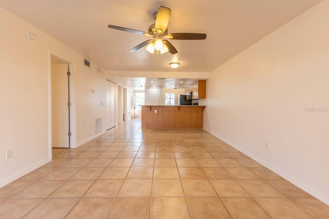 unfurnished living room with ceiling fan and light tile patterned flooring