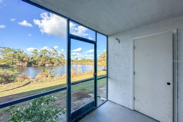 unfurnished sunroom featuring a water view