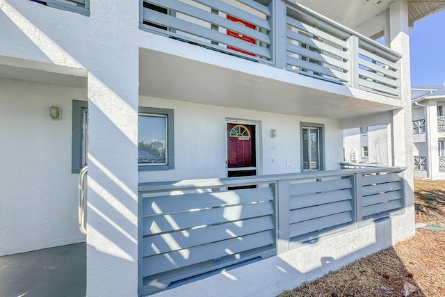 view of exterior entry with a balcony