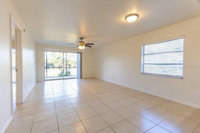 spare room with ceiling fan and light tile patterned floors