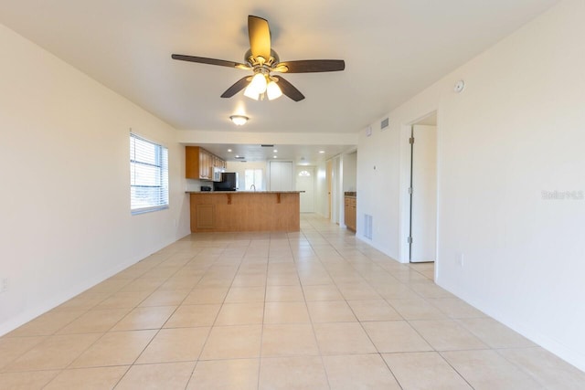 unfurnished living room featuring ceiling fan and light tile patterned floors