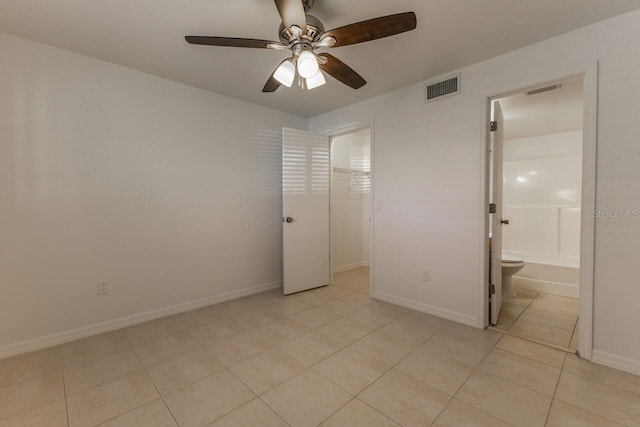 unfurnished bedroom featuring light tile patterned floors, ensuite bath, and ceiling fan