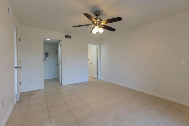 tiled spare room with ceiling fan