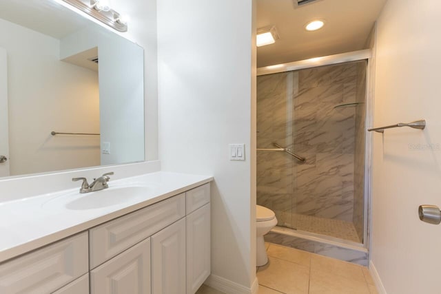 bathroom with tile patterned flooring, vanity, a shower with shower door, and toilet