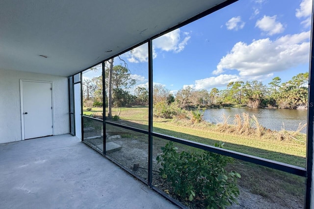 unfurnished sunroom featuring a water view