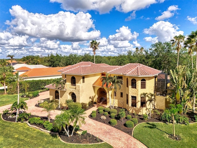 mediterranean / spanish-style house featuring a lanai and a front lawn