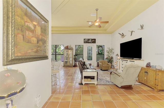 living room featuring ceiling fan, a towering ceiling, and light tile patterned flooring