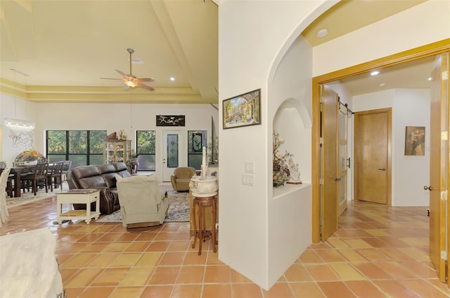 living room featuring a towering ceiling, a barn door, ceiling fan, and light tile patterned flooring