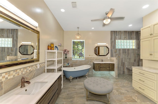 bathroom with separate shower and tub, ceiling fan, vanity, and tile walls