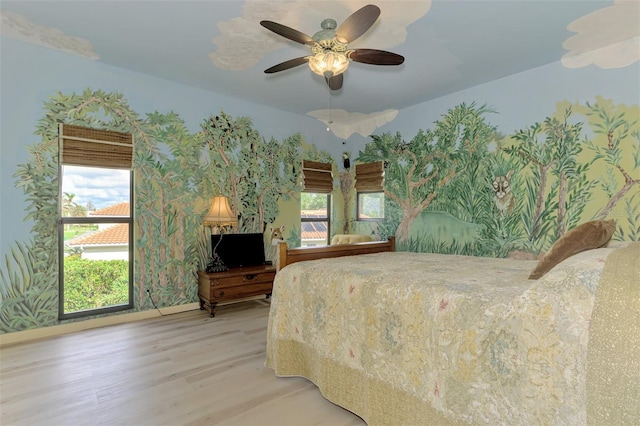 bedroom with hardwood / wood-style floors, ceiling fan, and multiple windows