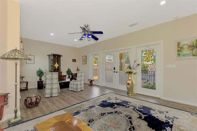 living area with hardwood / wood-style floors, ceiling fan, and french doors