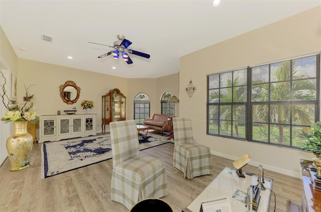 living room with a wealth of natural light, ceiling fan, and light hardwood / wood-style floors