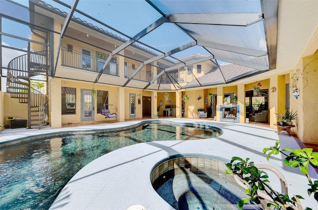 view of pool with an in ground hot tub, a patio, and glass enclosure