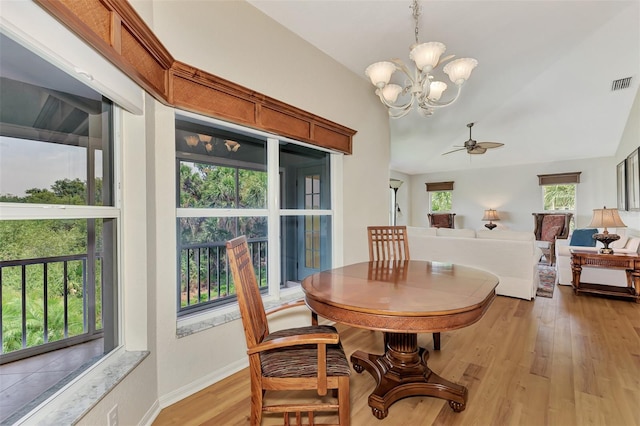 dining room with a wealth of natural light, ceiling fan with notable chandelier, and light hardwood / wood-style flooring