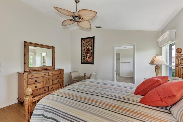 bedroom featuring ceiling fan, wood-type flooring, connected bathroom, and lofted ceiling