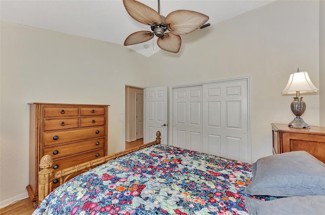 bedroom with light hardwood / wood-style floors, ceiling fan, a closet, and lofted ceiling