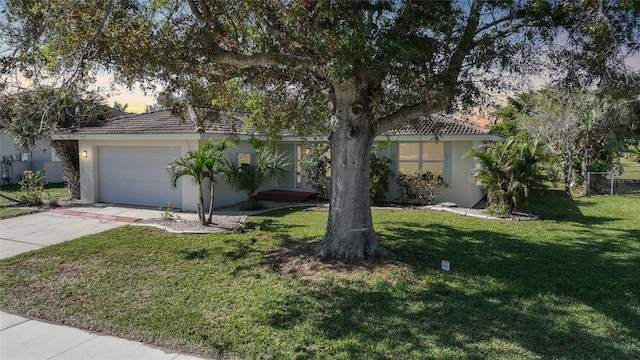 view of front of property with a garage and a lawn