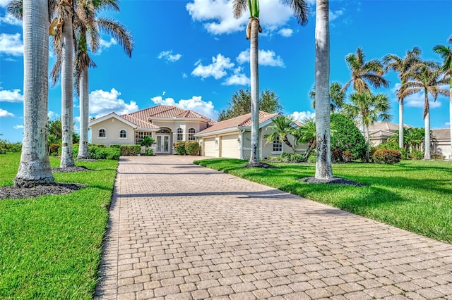 mediterranean / spanish home with a garage and a front yard