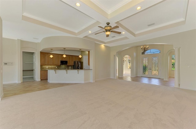 unfurnished living room featuring french doors, coffered ceiling, beamed ceiling, crown molding, and light colored carpet