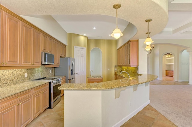 kitchen featuring light stone countertops, hanging light fixtures, stainless steel appliances, kitchen peninsula, and light colored carpet