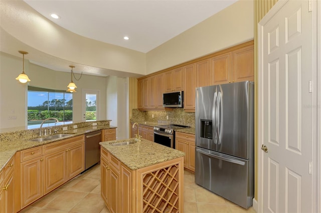 kitchen featuring sink, stainless steel appliances, decorative light fixtures, a kitchen island with sink, and light tile patterned floors