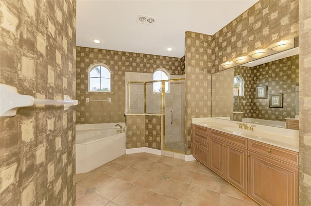 bathroom with tile patterned floors, vanity, and shower with separate bathtub