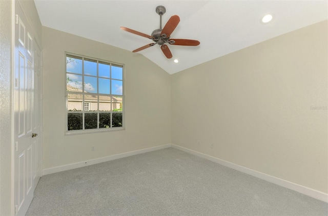 spare room featuring ceiling fan, light colored carpet, and lofted ceiling