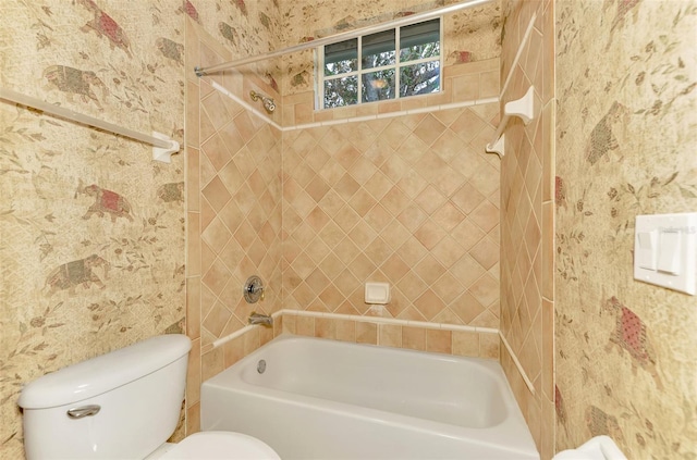 bathroom featuring tiled shower / bath combo and toilet