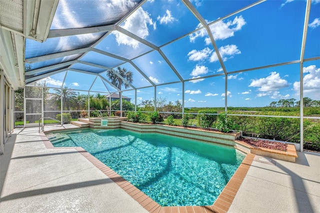 view of pool with glass enclosure and a patio