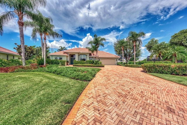 mediterranean / spanish house featuring a garage and a front lawn