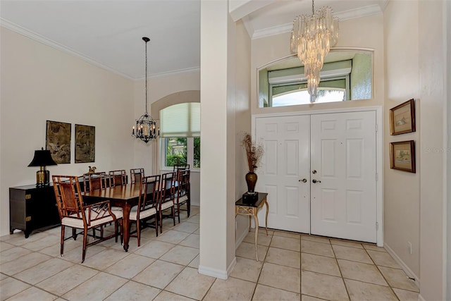 foyer featuring plenty of natural light, light tile patterned floors, ornamental molding, and a chandelier