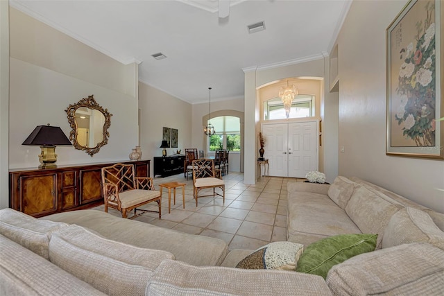 tiled living room featuring crown molding and an inviting chandelier