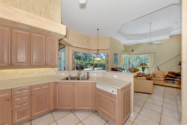 kitchen with kitchen peninsula, a tray ceiling, ceiling fan, sink, and pendant lighting