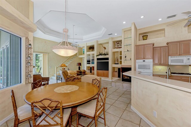 tiled dining space featuring a tray ceiling