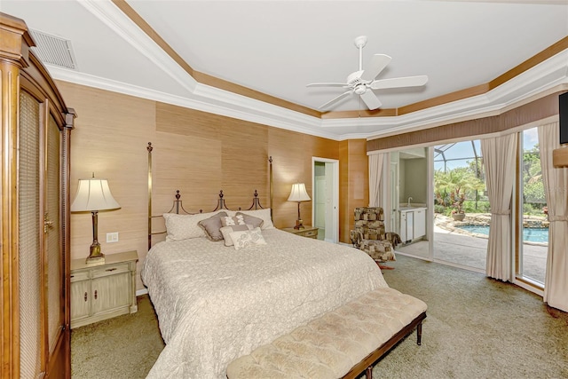 carpeted bedroom with access to outside, ceiling fan, crown molding, and a tray ceiling