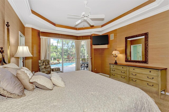 bedroom with carpet, ceiling fan, access to exterior, ornamental molding, and a tray ceiling