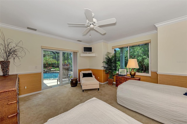 carpeted bedroom with multiple windows, wood walls, and ceiling fan