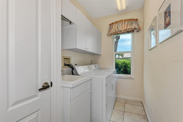 laundry room featuring cabinets, light tile patterned floors, and separate washer and dryer