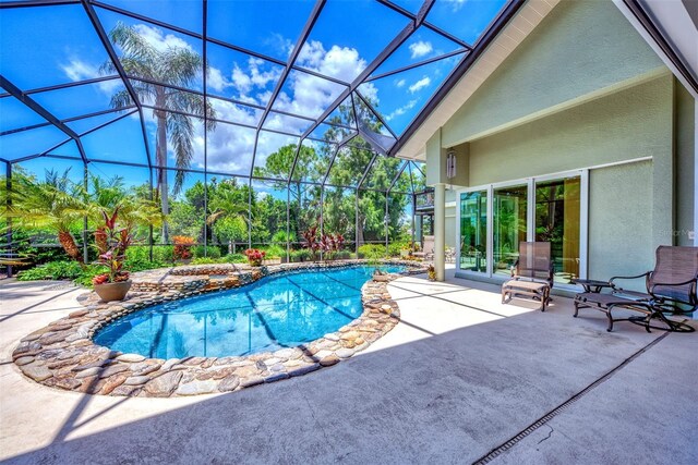 view of swimming pool with a lanai and a patio area