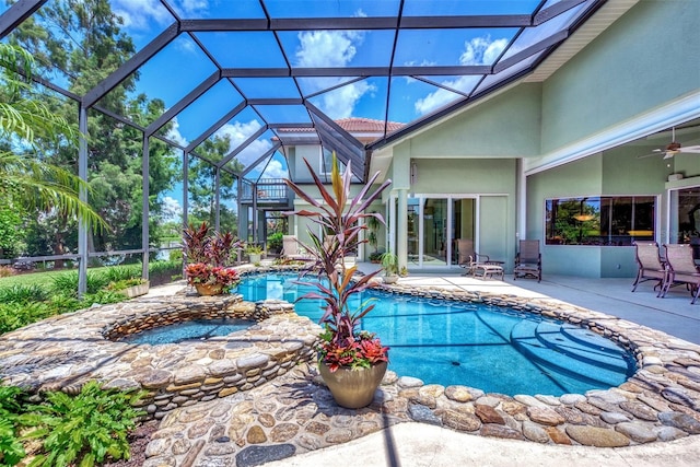 view of swimming pool with glass enclosure, ceiling fan, and a patio area