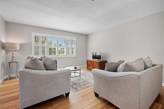 living room featuring a textured ceiling and light hardwood / wood-style flooring