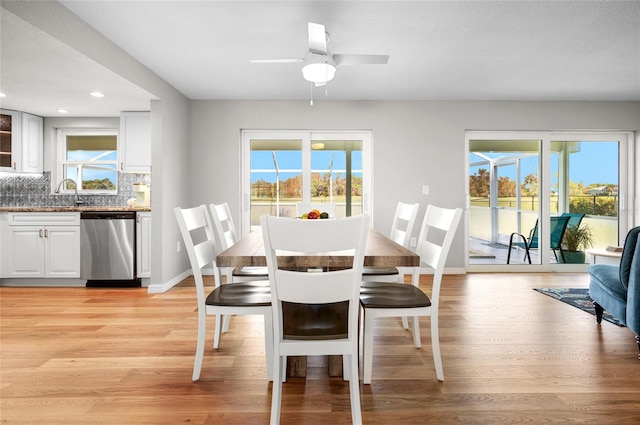 dining area featuring light hardwood / wood-style floors, ceiling fan, and sink